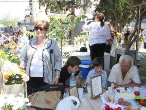 Μέλη ποντιακής οικογένειας τιμούν το ταφικό έθιμο στο κοιμητήριο