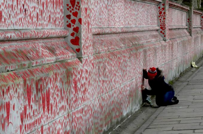 γυναίκα γράφει στον τοίχο με τις καρδιές