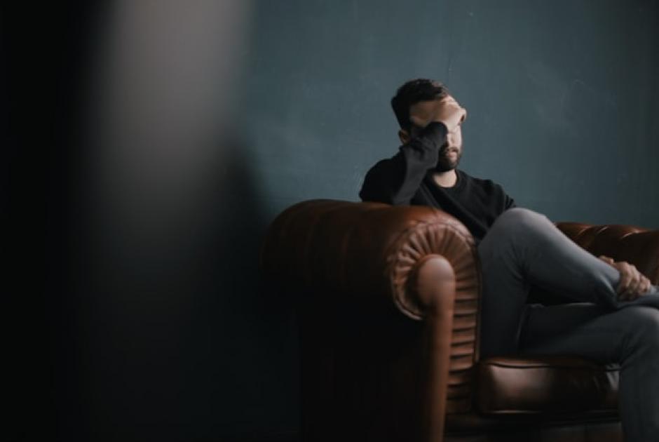 κατάθλιψη άνδρες άνδρας κρατάει τον κεφάλι του και κάθεται σε καναπέ